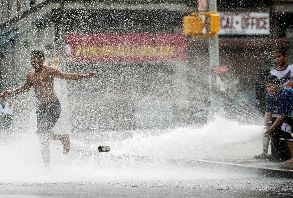 Hydranten, die Wasser auf die Straße schießen – eine Sommertradition in New York